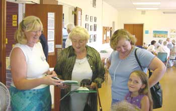 Author of 'A Village School', Annette Booth, shows Rosemary Fittock (centre) her picture in the book